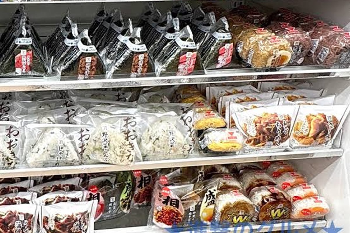 Shelves filled with different kinds of onigiri at a Japanese 7-Eleven