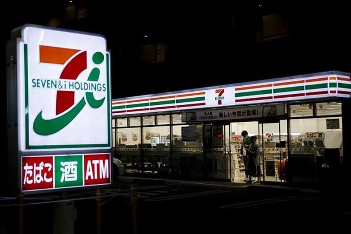 A Japanese 7-Eleven at night with its sign and entrance visible