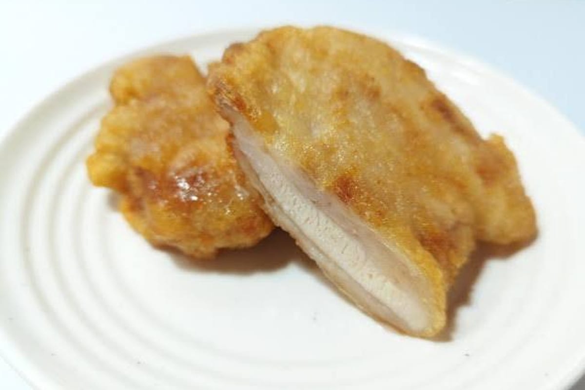 Fried chicken cut open to show the coating and meat inside