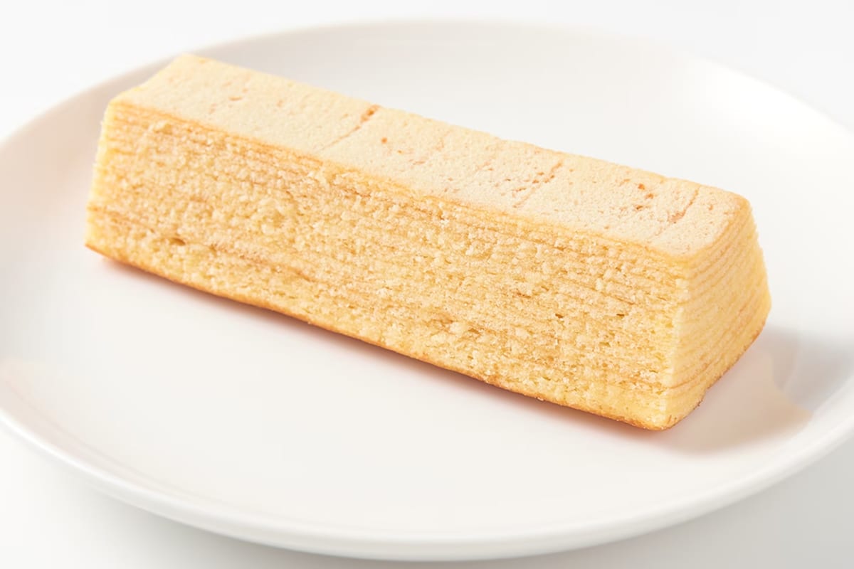 A bar of MUJI Fuzoroi Baum on a white plate, with the baked layers visible at the cut end