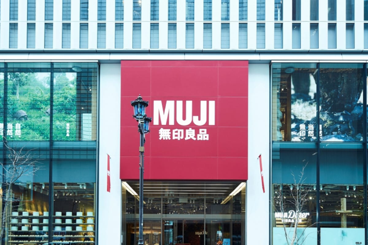 The exterior of a MUJI store in Japan, with the red MUJI sign above the entrance